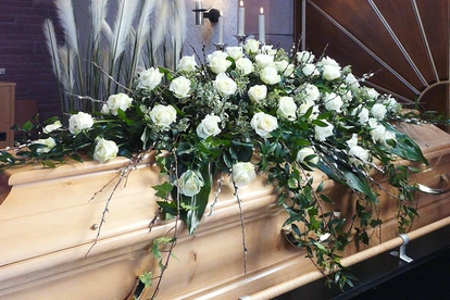 Sargschmuck mit weißen Rosen