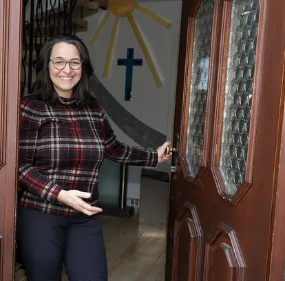 Simone Rühle hält mit freundlichem Lächeln die Türe auf